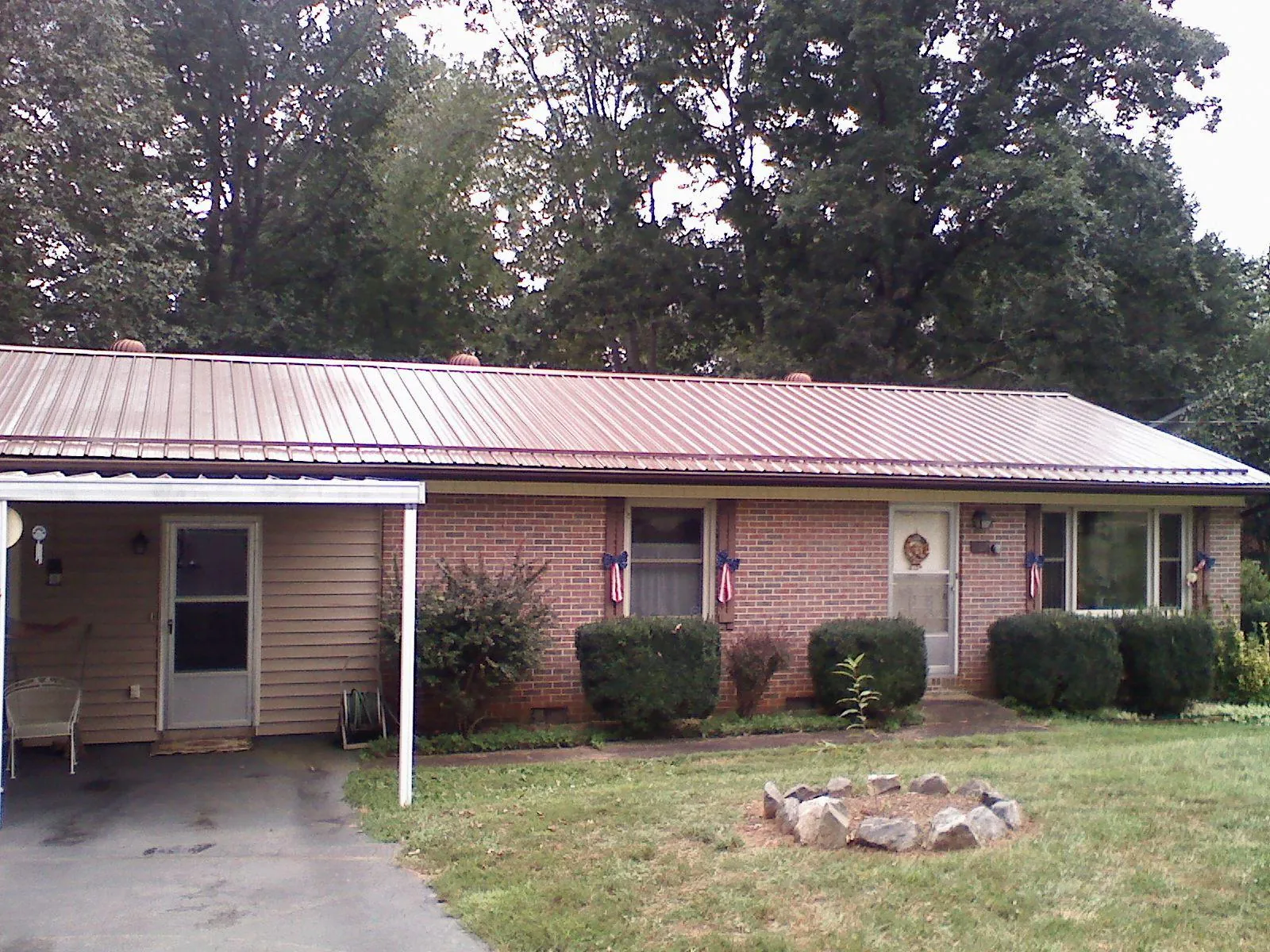Bronze metal roof and carport on a brick ranch home — Roof Repair work by our crew in Marietta